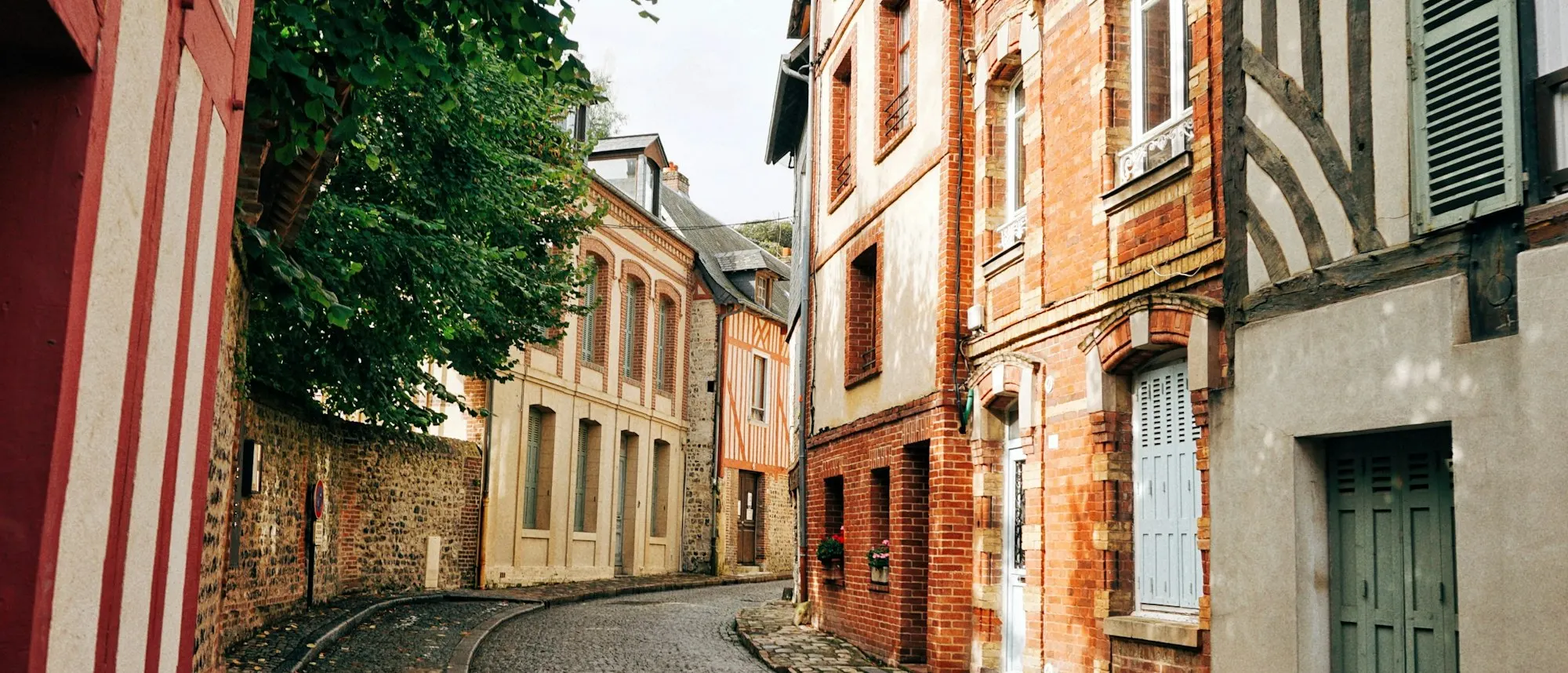 Une rue pavée bordée de maisons anciennes à Honfleur, en Normandie
